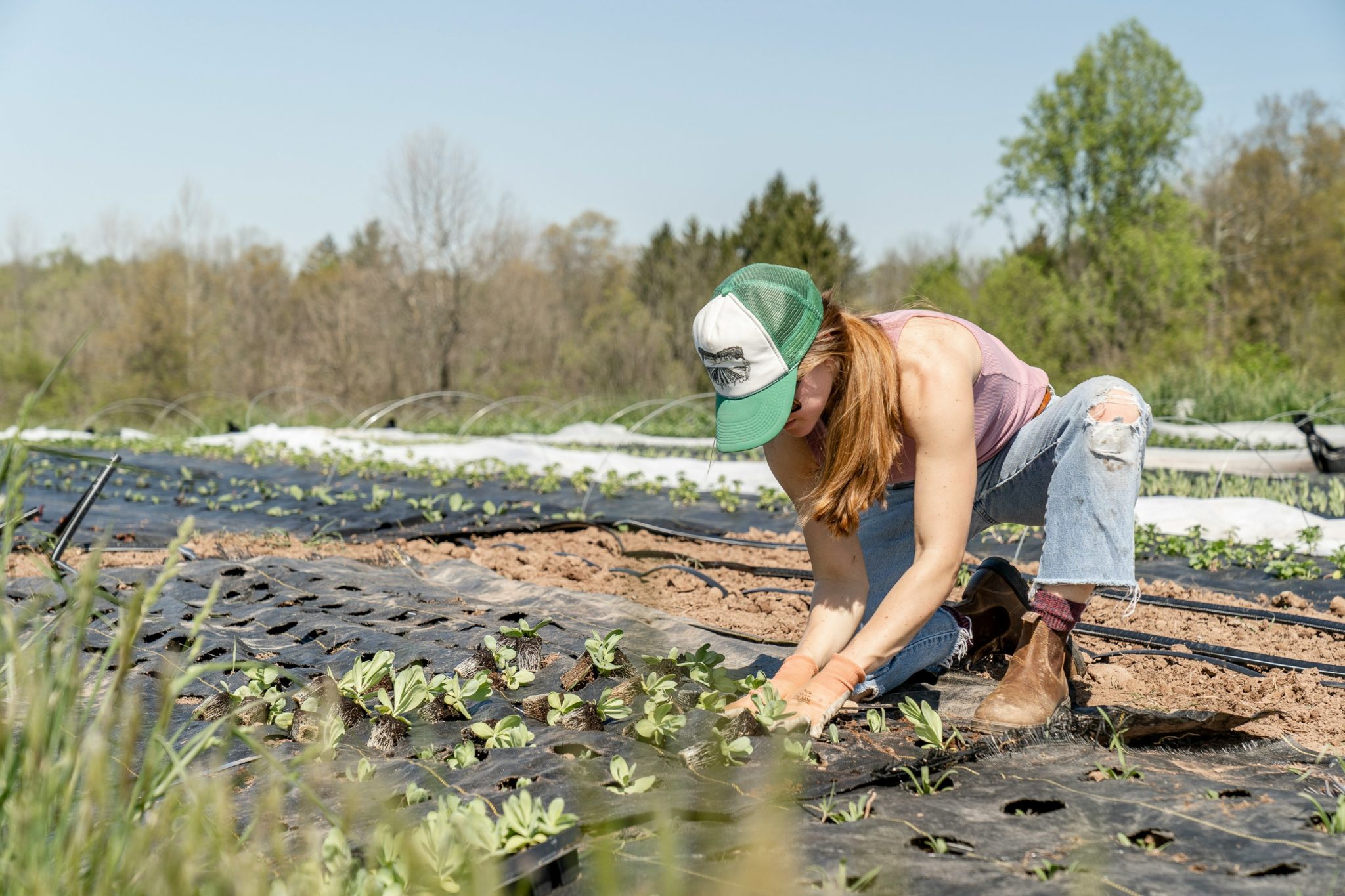 Une agricultrice qui sème des légumes.